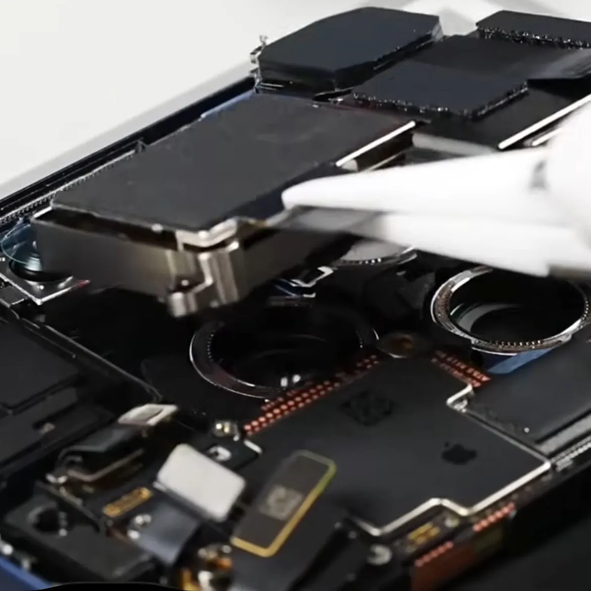 Técnico reparando a placa lógica de um iPhone no laboratório da innPhone Curitiba