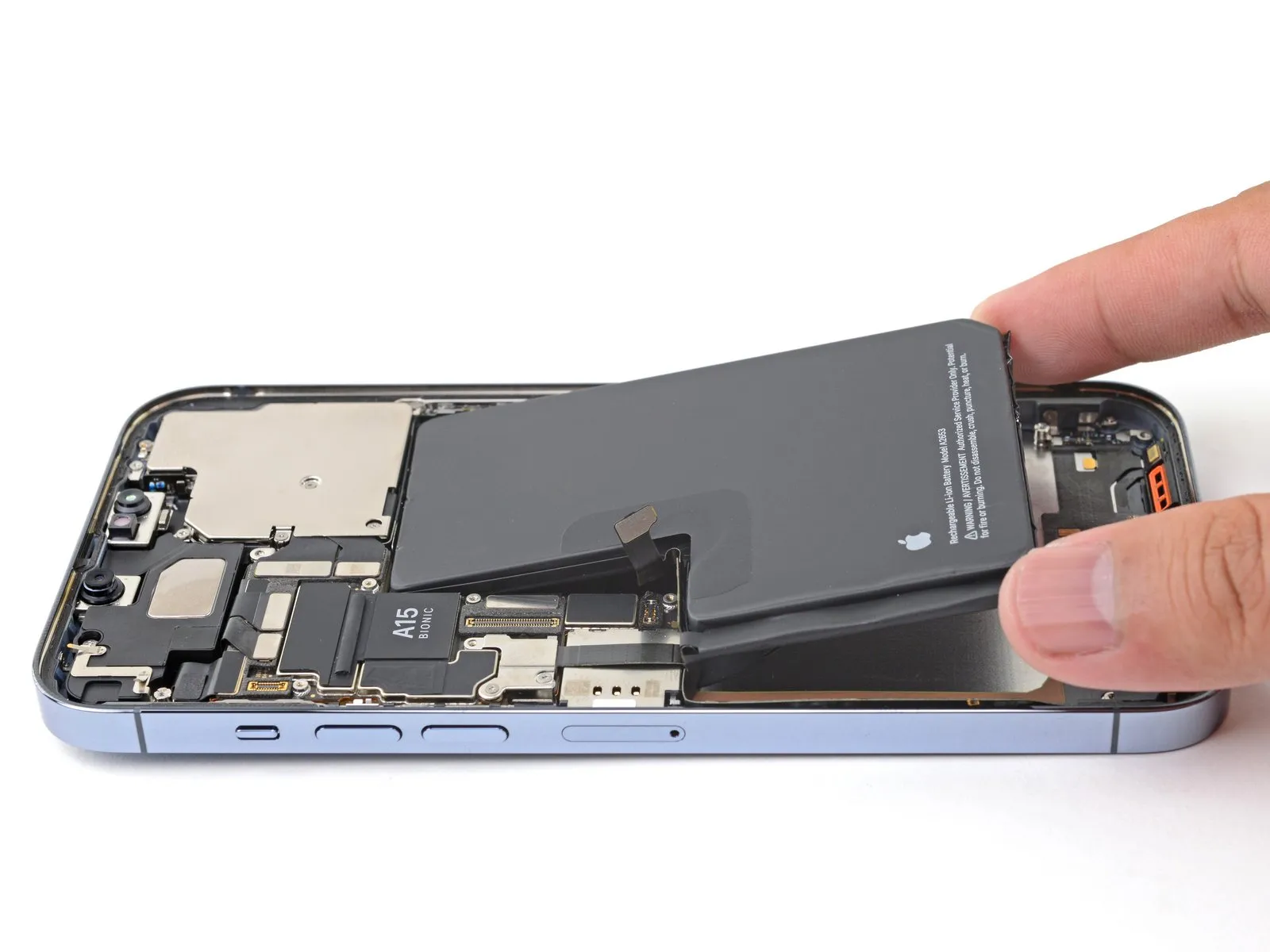 Bateria sendo retirada de um iPhone aberto, em uma troca de bateria feita em bancada